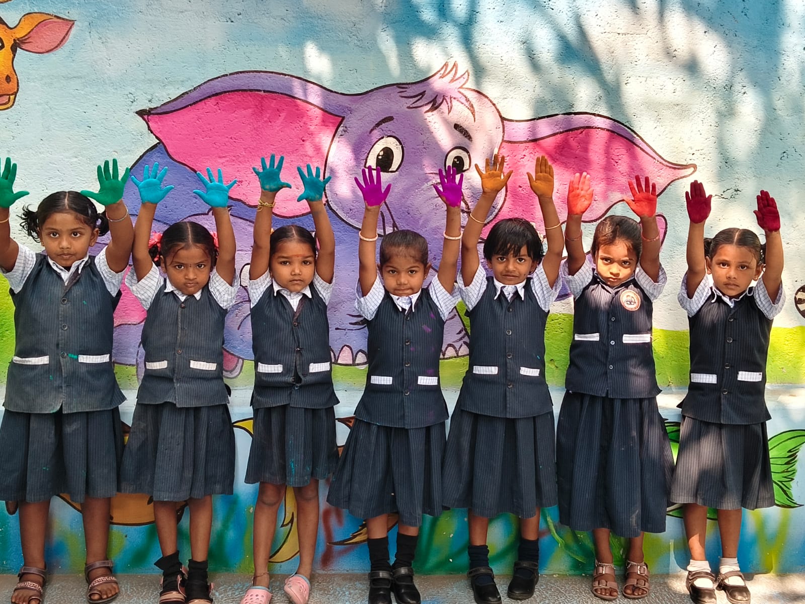 Young girls with painted hands raised